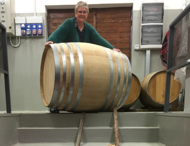 LAGER EGEN VIN: Hilde poserer foran vintønnen i gårdens egen cantina. Foto: Privat LAGER EGEN VIN: Hilde poserer foran vintønnen i gårdens egen cantina. Foto: Privat